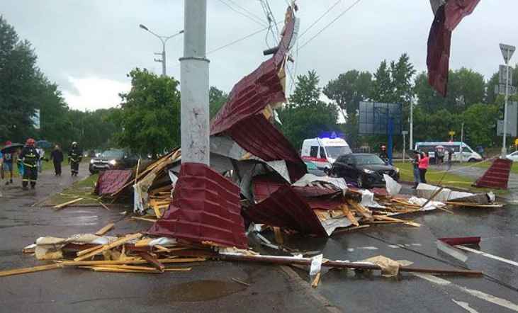 В Минске ветер сорвал крышу дома и бросил на машины на дороге